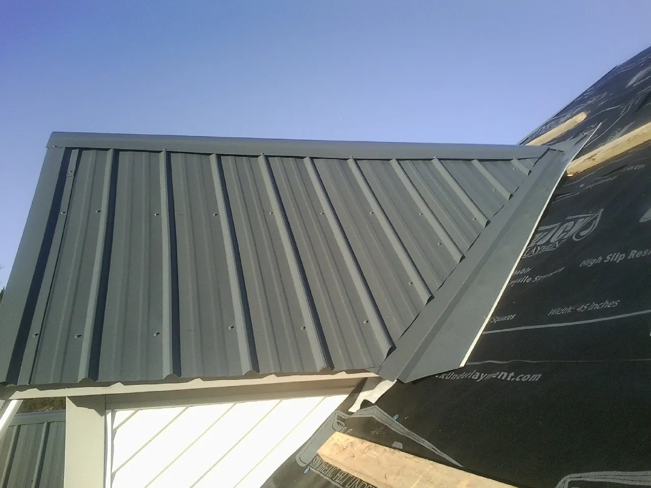 Gray metal roof panels going on over a garage gable in Lovettsville