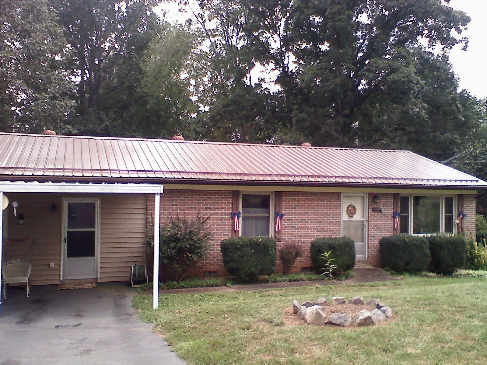 Bronze metal roof and carport on a brick ranch home — Roof Repair work by our crew in Lovettsville